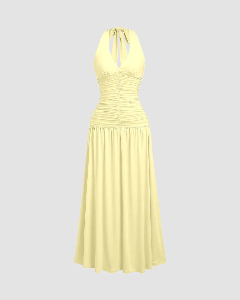 Ruched halter neck vanilla midi dress featuring a gathered bust and flowy silhouette with a standout backless detail.