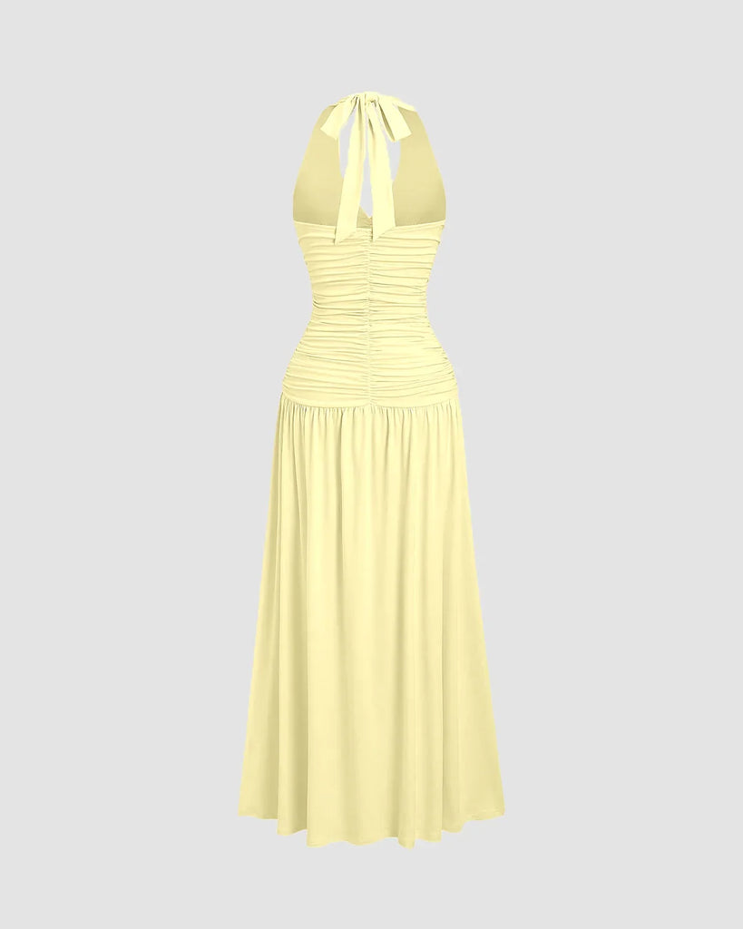 Back view of a Ruched halter neck vanilla midi dress featuring a gathered bust and flowy silhouette with a standout backless detail.