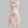 Front view of Cowl neck bodycon mini dress with soft draped neckline, ruched side detail, and delicate pink floral print on a fitted silhouette.
