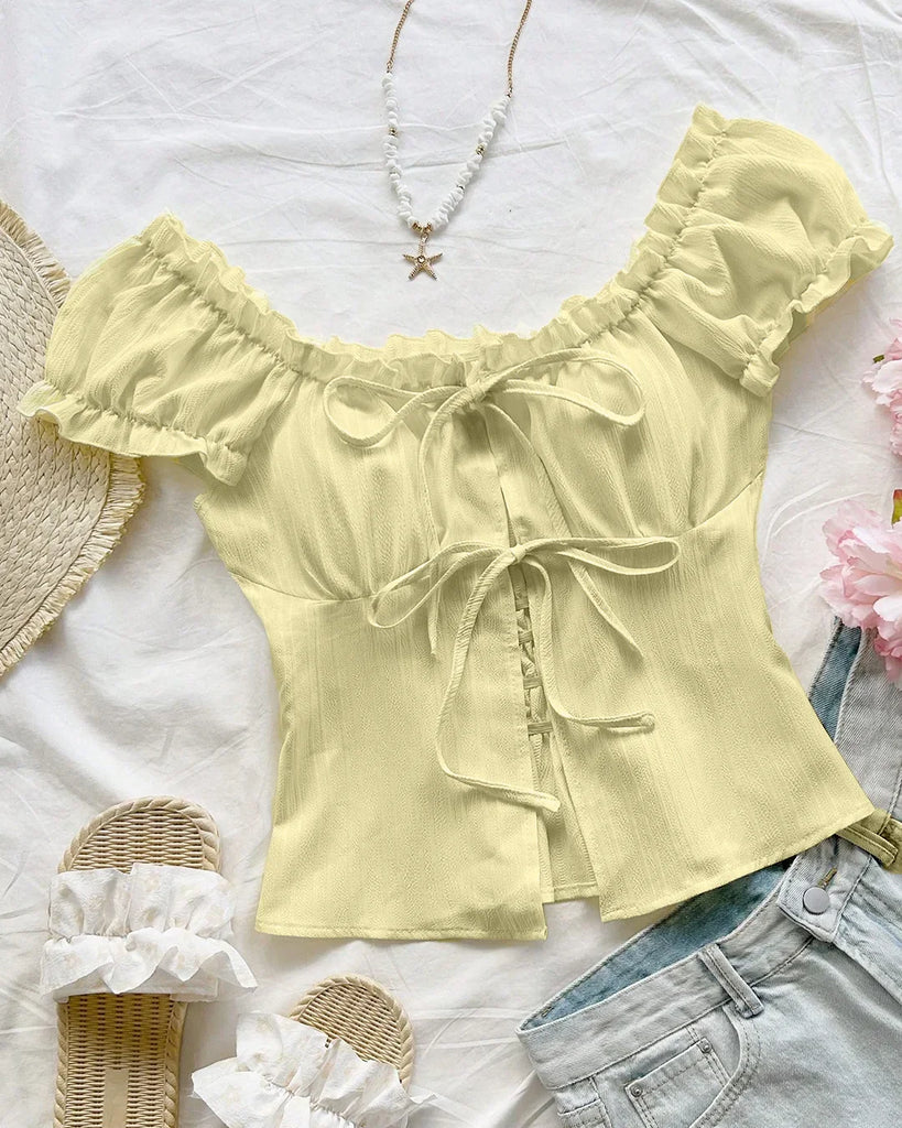 Back view of a French Vanilla blouse featuring ruffled sleeves and a bow tie front design in a vibrant yellow.