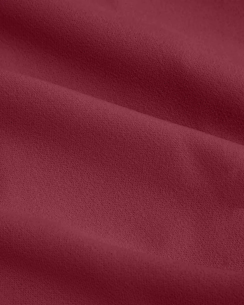 Closed view of a burgundy A-line midi dress featuring a side tie knot at the waist, designed for a flattering silhouette.