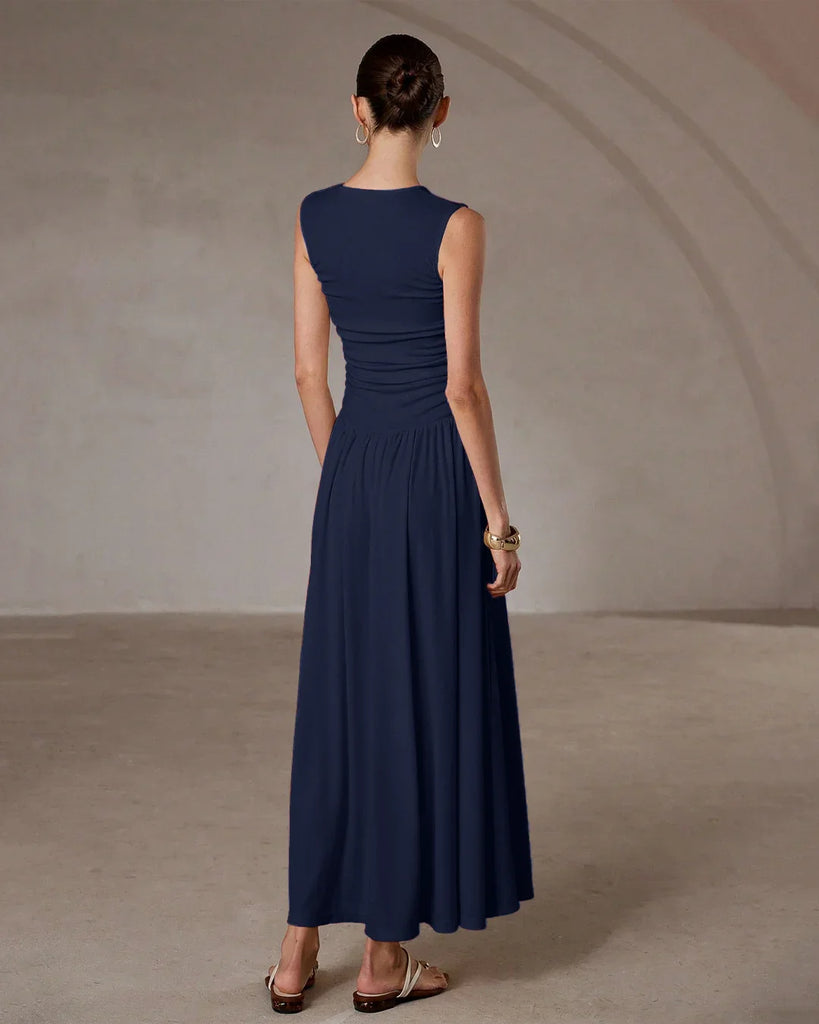 Model in a sleeveless navy blue maxi dress with a ruched waist.