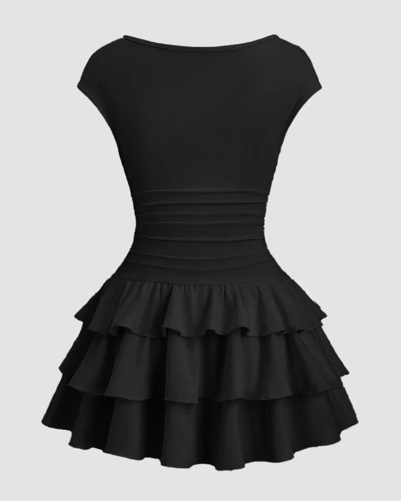 Back view of a Black mini dress featuring a ruched waist and a tiered ruffle skirt, perfect for a stylish and elegant look.