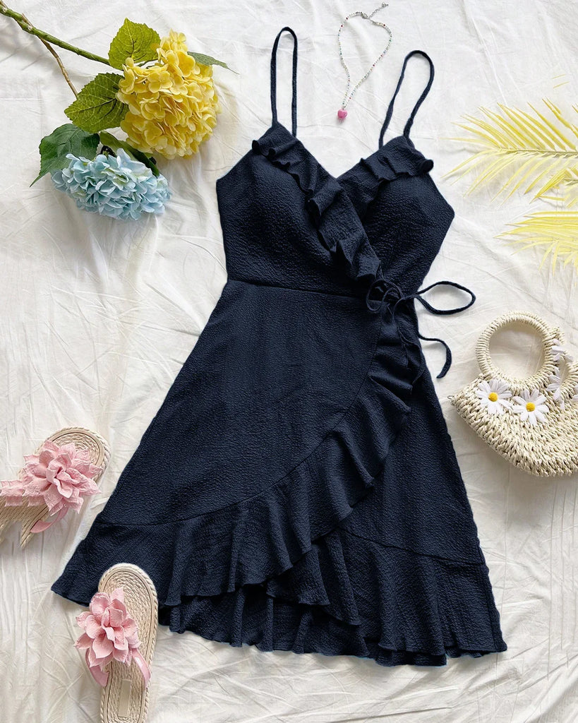 A navy blue ruffled wrap spaghetti strap dress paired with stylish sandals.