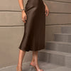 Front view of Brown flared midi skirt with smooth satin finish, fitted waist, and flowing hem for an elegant casual look.