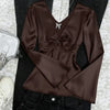 Front view of Coffee brown satin deep V-neck top with a front tie detail and long flare sleeves, offering a sleek, fitted and elegant silhouette