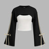Black and white cropped top featuring a white bow, styled as a side-striped sweatshirt and solid cami.