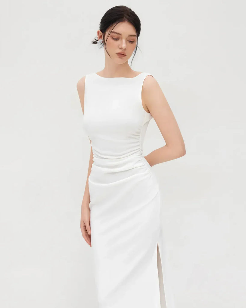 A sleeveless white midi dress featuring a ruched neckline and a boat neck design, elegantly draped for a flattering fit.