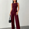 Woman Wearing Sleeveless burgundy jumpsuit with a buttoned vest and wide-leg trousers.