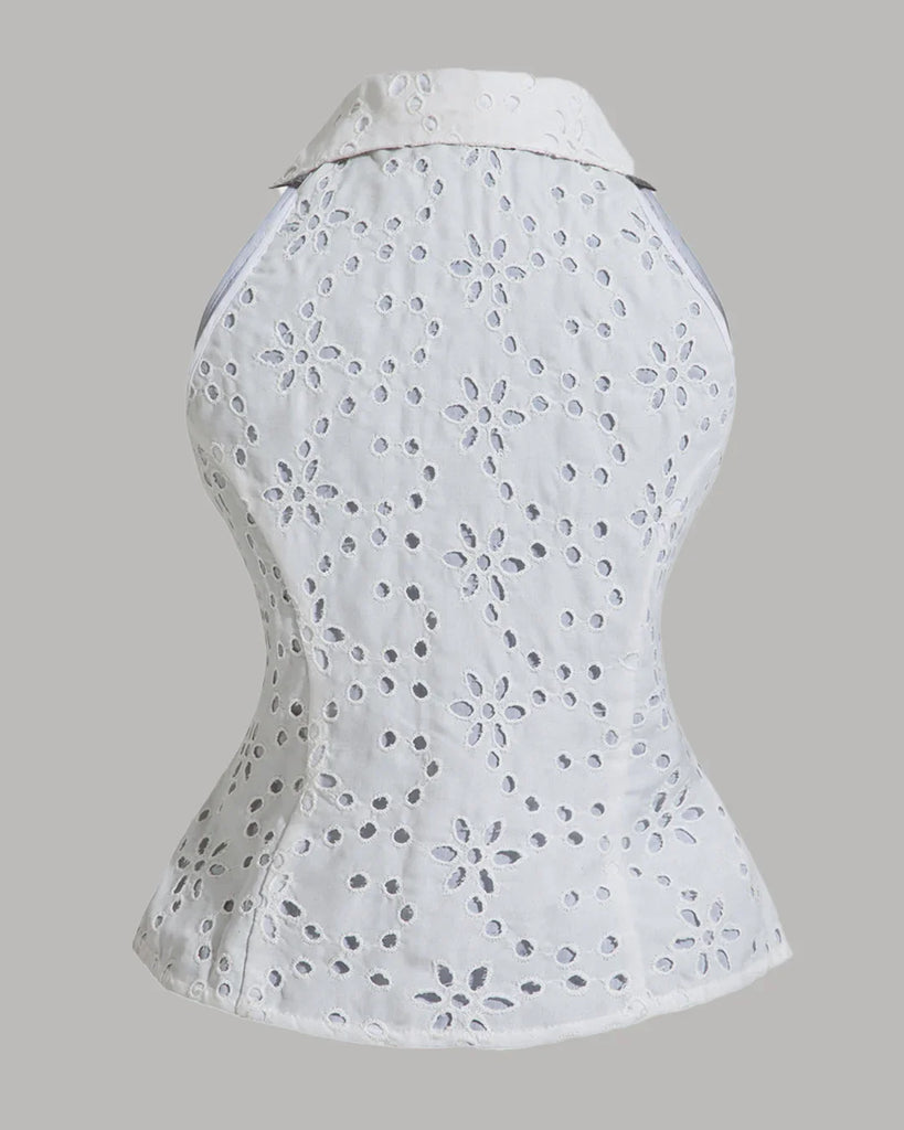 Back view of a sleeveless white blouse featuring a floral pattern, designed as a collared button-down top with eyelet details.
