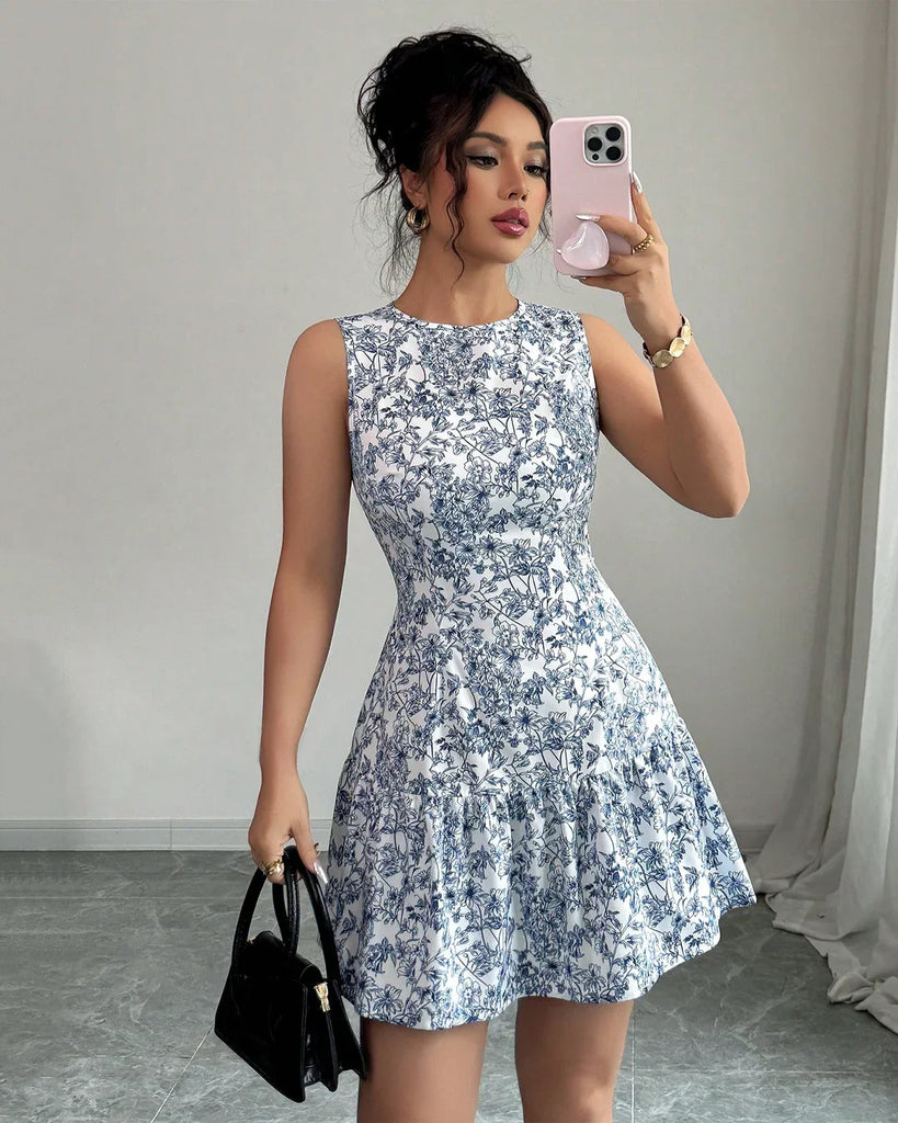 A woman in a sleeveless blue and white floral fit and flare mini dress