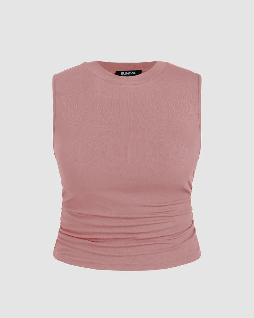 Pink sleeveless crop top with side ruching, designed for comfort and movement, perfect for a versatile wardrobe