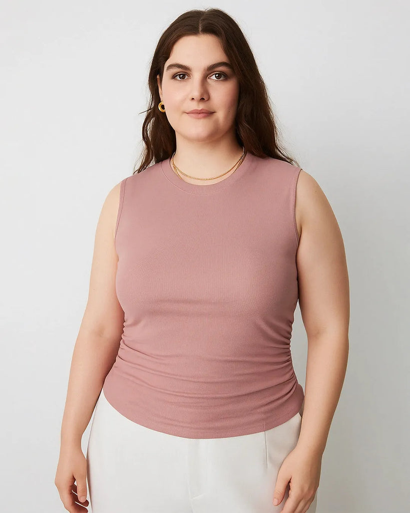 A women wearing pink sleeveless crop top with side ruching, designed for comfort and movement, perfect for a versatile wardrobe