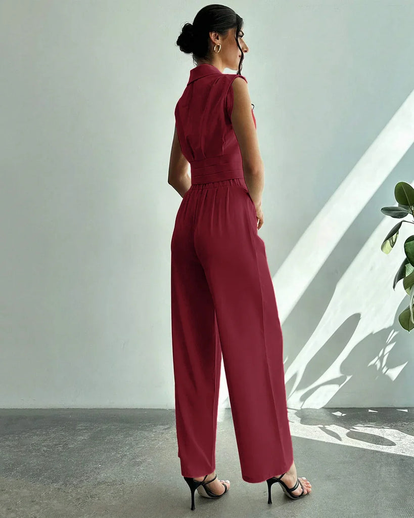 Back view of a woman in a red sleeveless jumpsuit and heels, showcasing a stylish co-ord set with pleated wide-leg trousers.