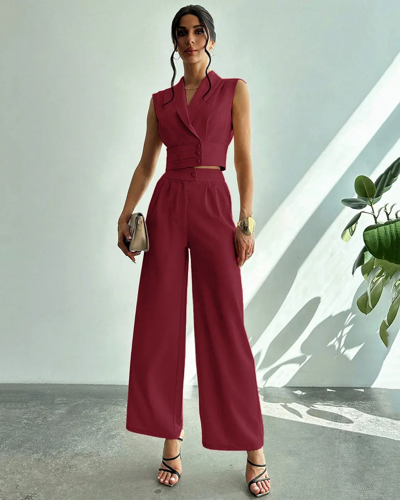 A woman in a red sleeveless jumpsuit and heels, showcasing a stylish co-ord set with pleated wide-leg trousers.