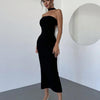 woman showcases a sexy, backless black dress featuring a prominent white bow tie detail front view