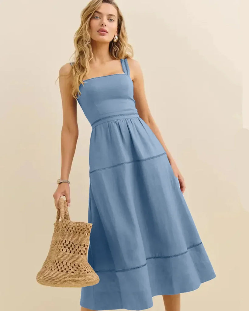 Model wearing a smocked back strap midi dress in French blue, showcasing a stylish and elegant design.