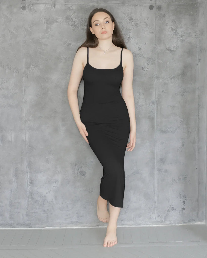 A sleek black maxi dress featuring thin straps and a contoured silhouette, offering a refined and effortlessly elegant look.