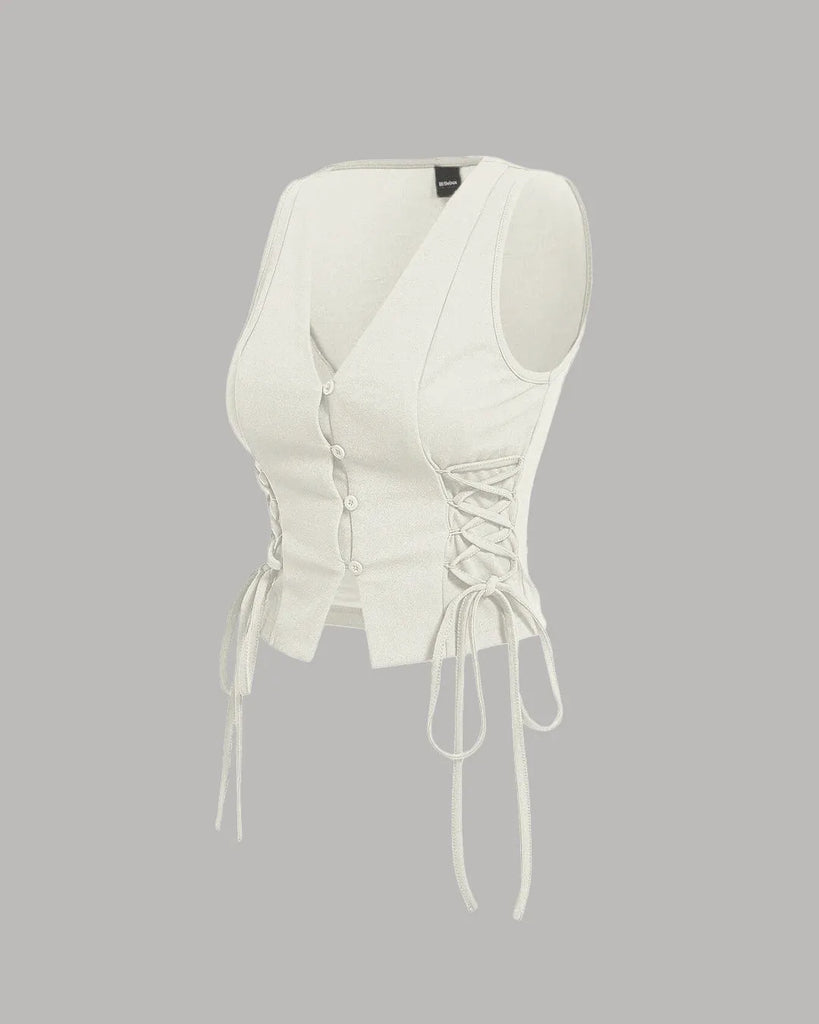 Milky white crop tank top with cross tie straps and lace-up sides, featuring a button-down detail for a stylish look on a grey background