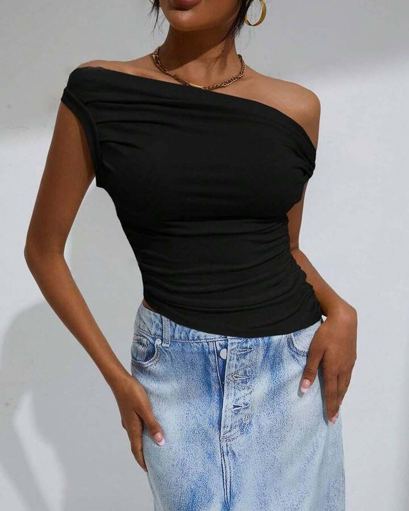 woman dressed in a black off-shoulder top paired with a denim skirt stands, highlighting her fashionable look close view