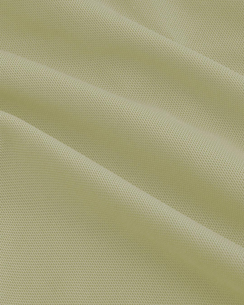 Close up of Herbal green dress with ruffles on the shoulders and a v-neck, featuring a bow tie at the waist.