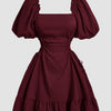  A maroon dress featuring ruffled sleeves and a lace-up side detail, showcasing a stylish and elegant design.