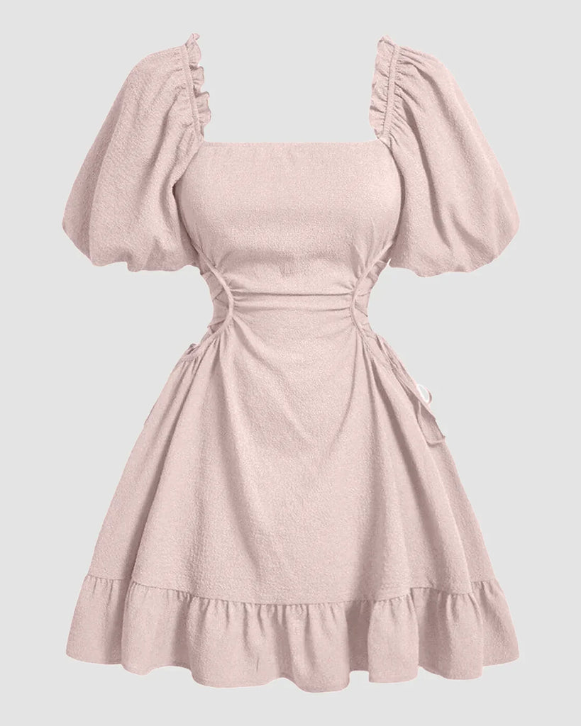 A powder pink dress featuring puff sleeves and ruffles, designed with a solid lace-up side detail.
