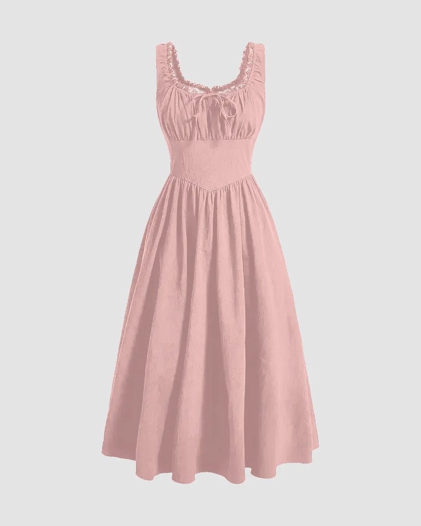 A solid powder pink dress featuring ruffles at the neckline and a ruched bust design.