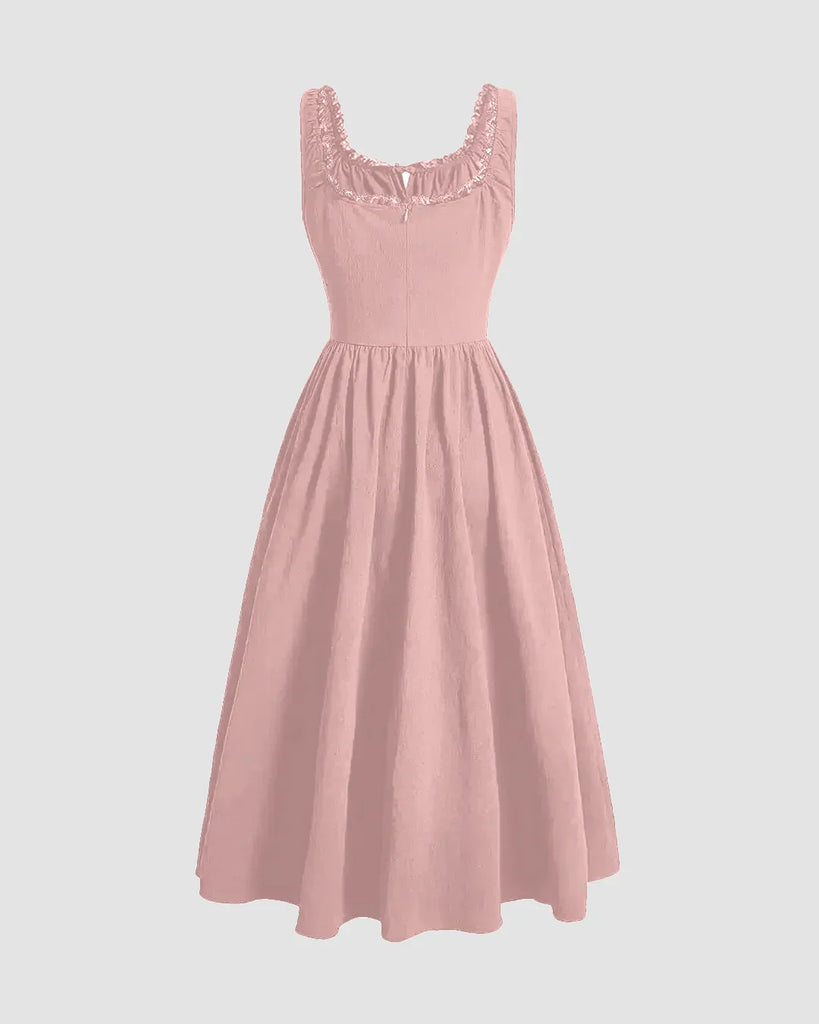 Back view of a solid powder pink dress featuring ruffles at the neckline and a ruched bust design.