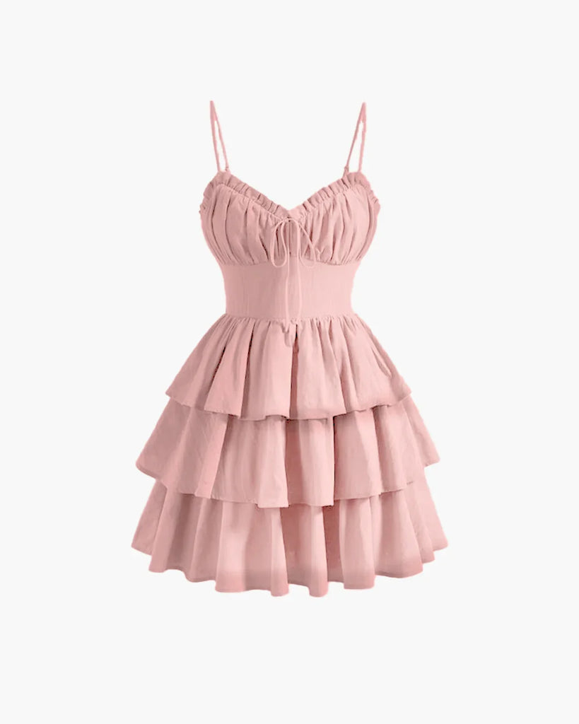 Powder pink cami dress featuring a ruched bust and ruffle hem for a soft, feminine touch.