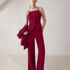 A model wearing a burgundy matching set, including a spaghetti strap button top and straight-leg trousers.