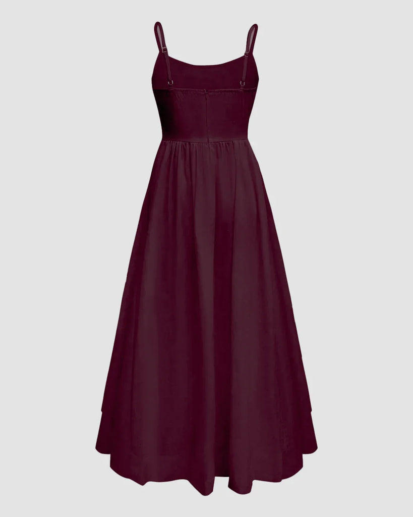 Burgundy spaghetti strap fit and flare sleeveless midi dress displayed on a mannequin against a neutral background.