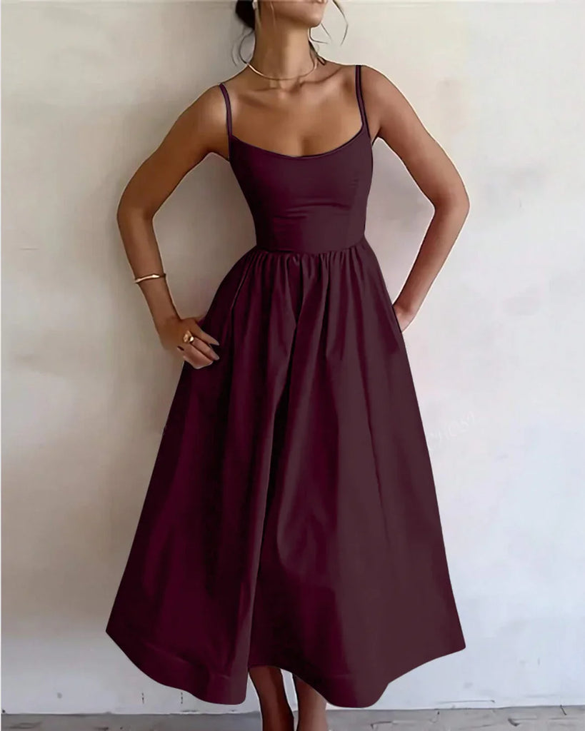 Burgundy spaghetti strap fit and flare sleeveless midi dress displayed on a mannequin against a neutral background.
