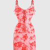 A baby pink spaghetti strap mini dress featuring red and white floral patterns on a mesh fabric.