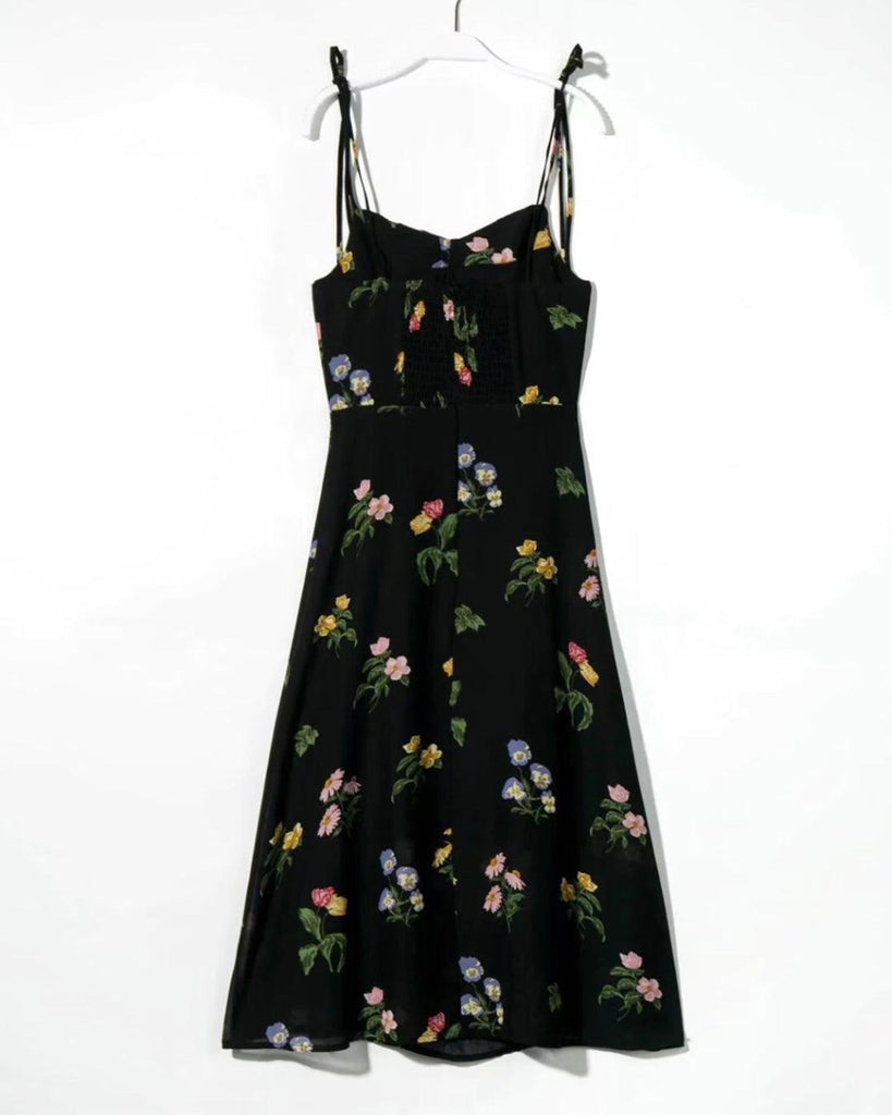woman wearing black floral spaghetti strap dress with a side slit backside