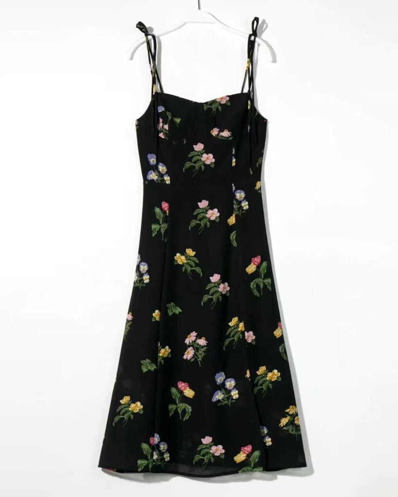 woman wearing black floral spaghetti strap dress with a side slit frontside