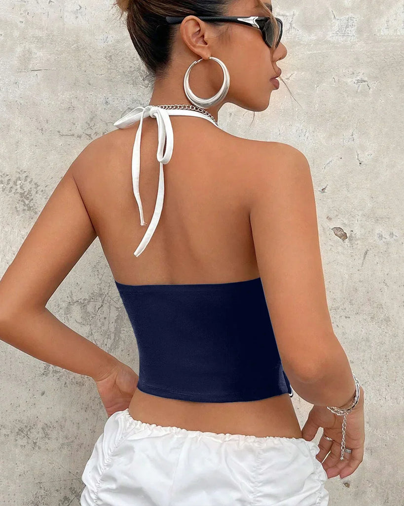 A women wearing navy blue and white sporty halter neck racerback top with ruched sides, perfect for an athletic look