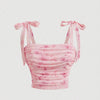 Front view of pink floral crop top featuring a bow on the shoulder and ruched detailing