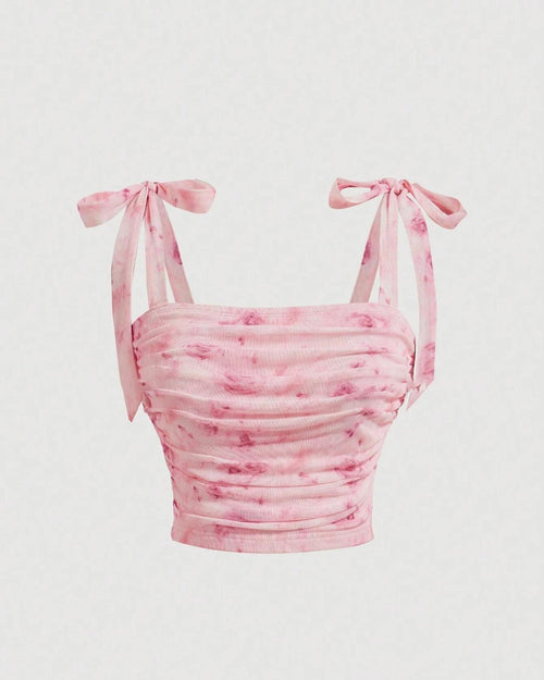 Front view of pink floral crop top featuring a bow on the shoulder and ruched detailing