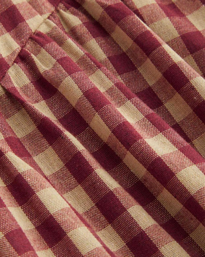 Close up of A red and white checkered maxi dress with a square neckline, showcasing a classic gingham pattern.
