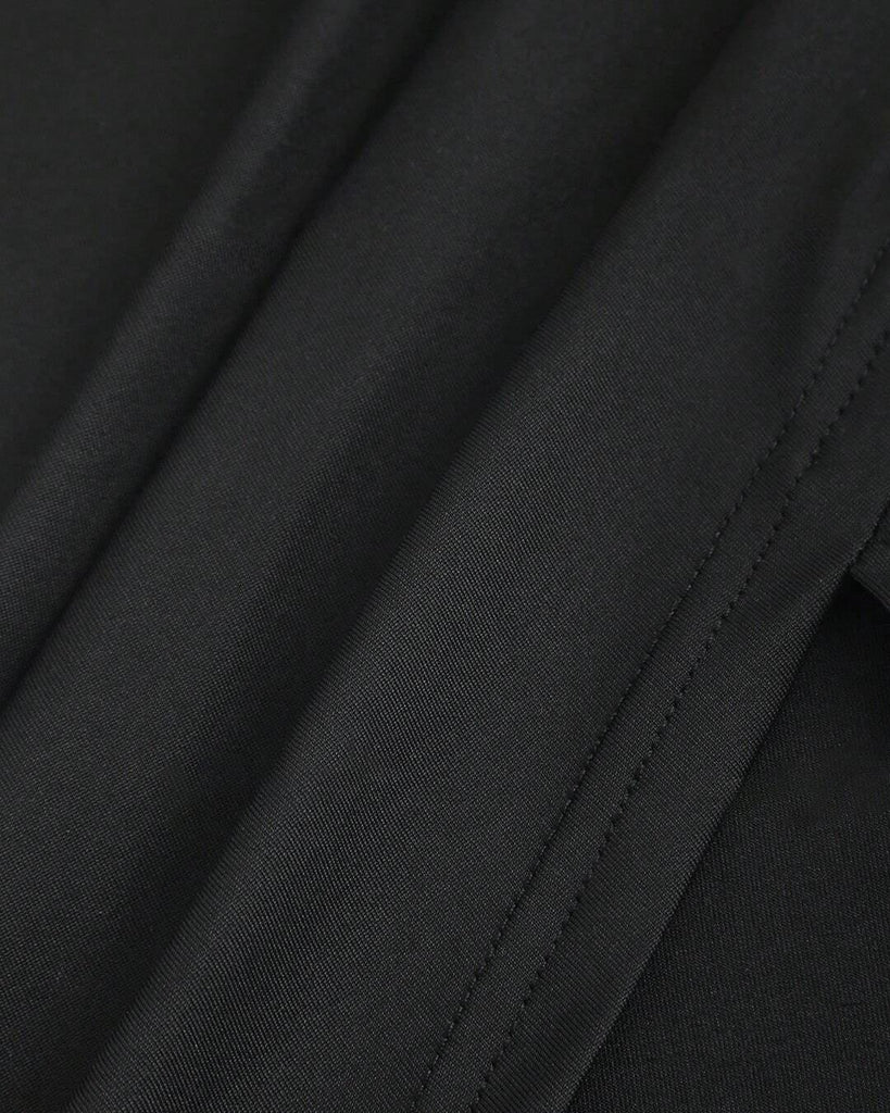 close view of black dress featuring a square neckline and short sleeves, designed with ruched detailing for a stylish look