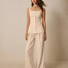 Model showcases a light khaki square neck sleeveless co-ord set with front buttons, paired with wide pants.