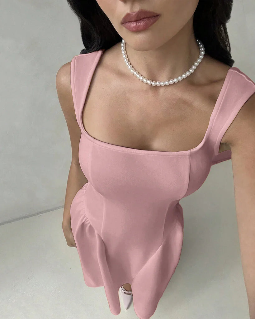 Model in a dusty pink sleeveless fit and flare midi dress featuring a square neckline.