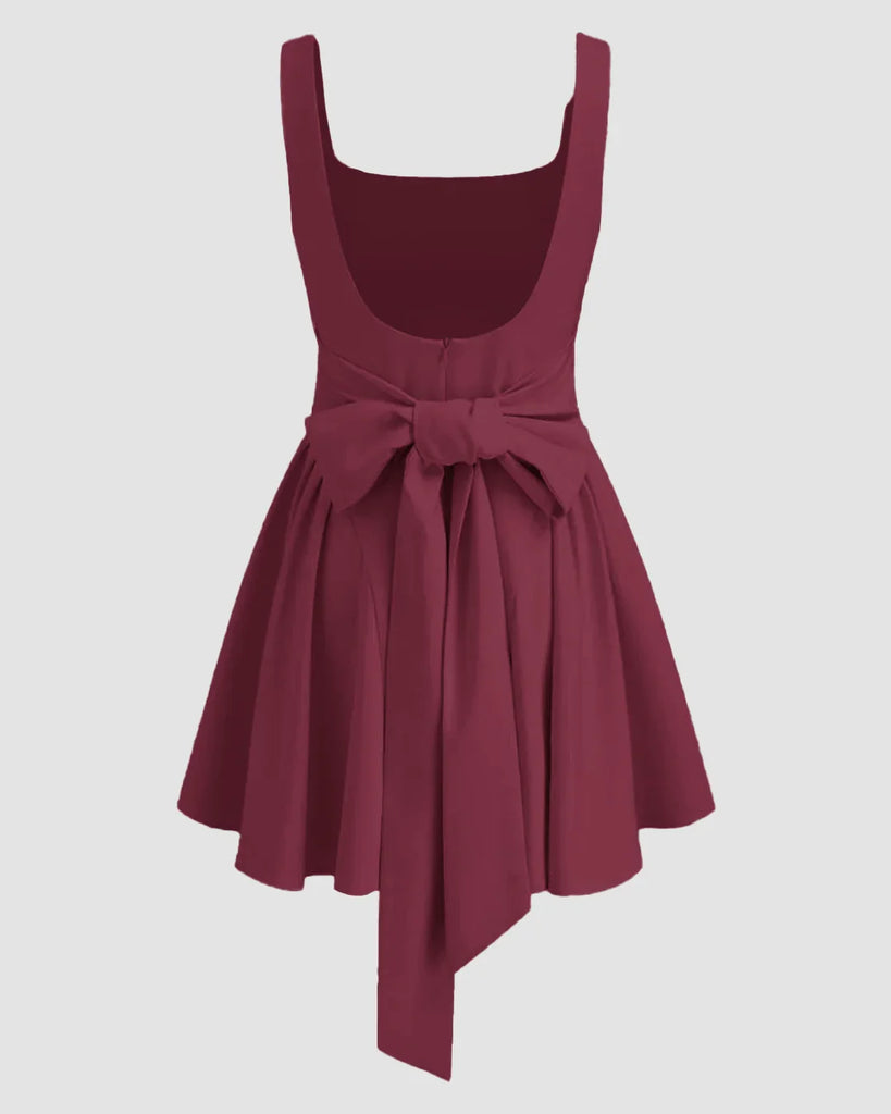 Back view of a Maroon mini dress with a square neckline, featuring ruffles and pleats, designed for a stylish and elegant look.
