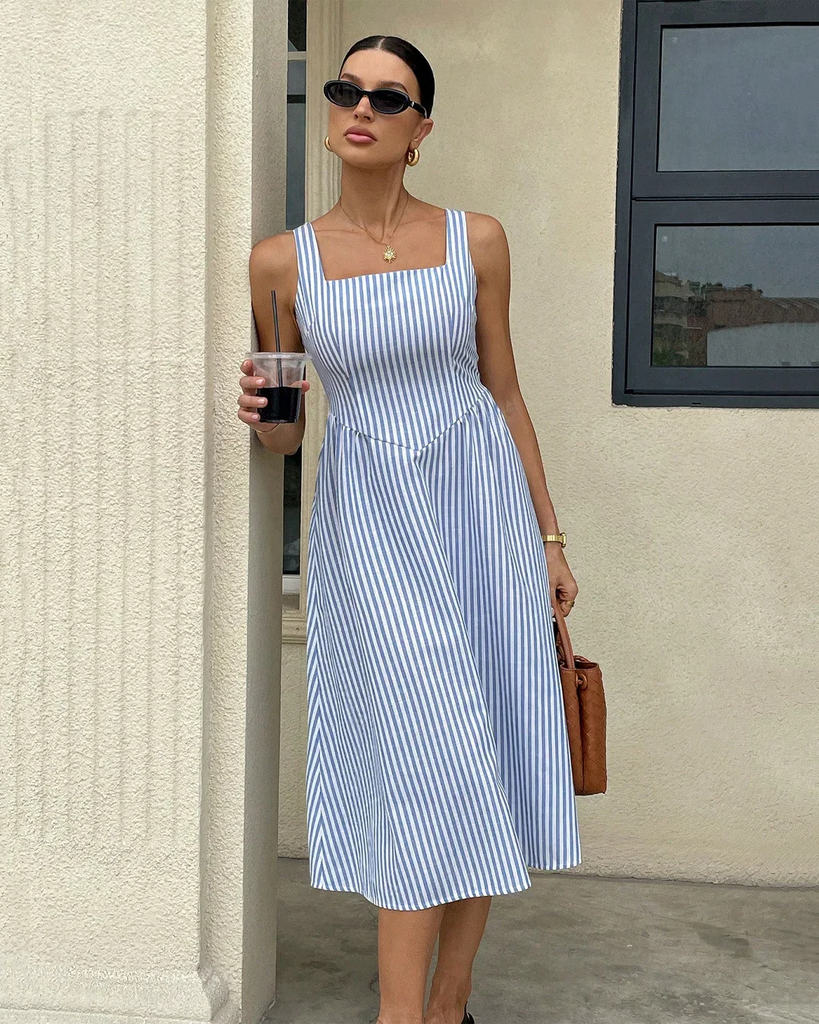 a blue and white striped midi dress with spaghetti straps and a square neckline.
