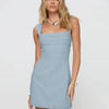  A model showcases a light blue dress featuring a square neckline and a ruffled hem, highlighting its elegant design.
