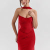 A women wearing red top and skirt set featuring a ruched halter-style top and a fitted skirt with sheer side panels for a bold evening look.