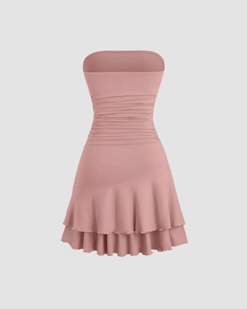 Back view of a rose-colored strapless mini dress featuring a fit-and-flare silhouette with layered hem detailing for a soft, sculpted look.