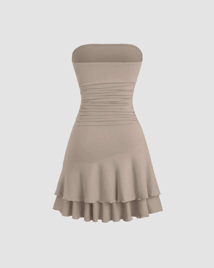 Back of a beige strapless mini dress featuring ruched detailing and layered fabric for a soft, sculpted silhouette.