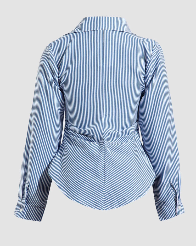 Back view of a Blue and white striped asymmetrical wrap shirt with long sleeves, showcasing a stylish and modern design.
